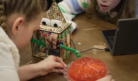 Kinderen experimenteren met een rood hersenmodel.